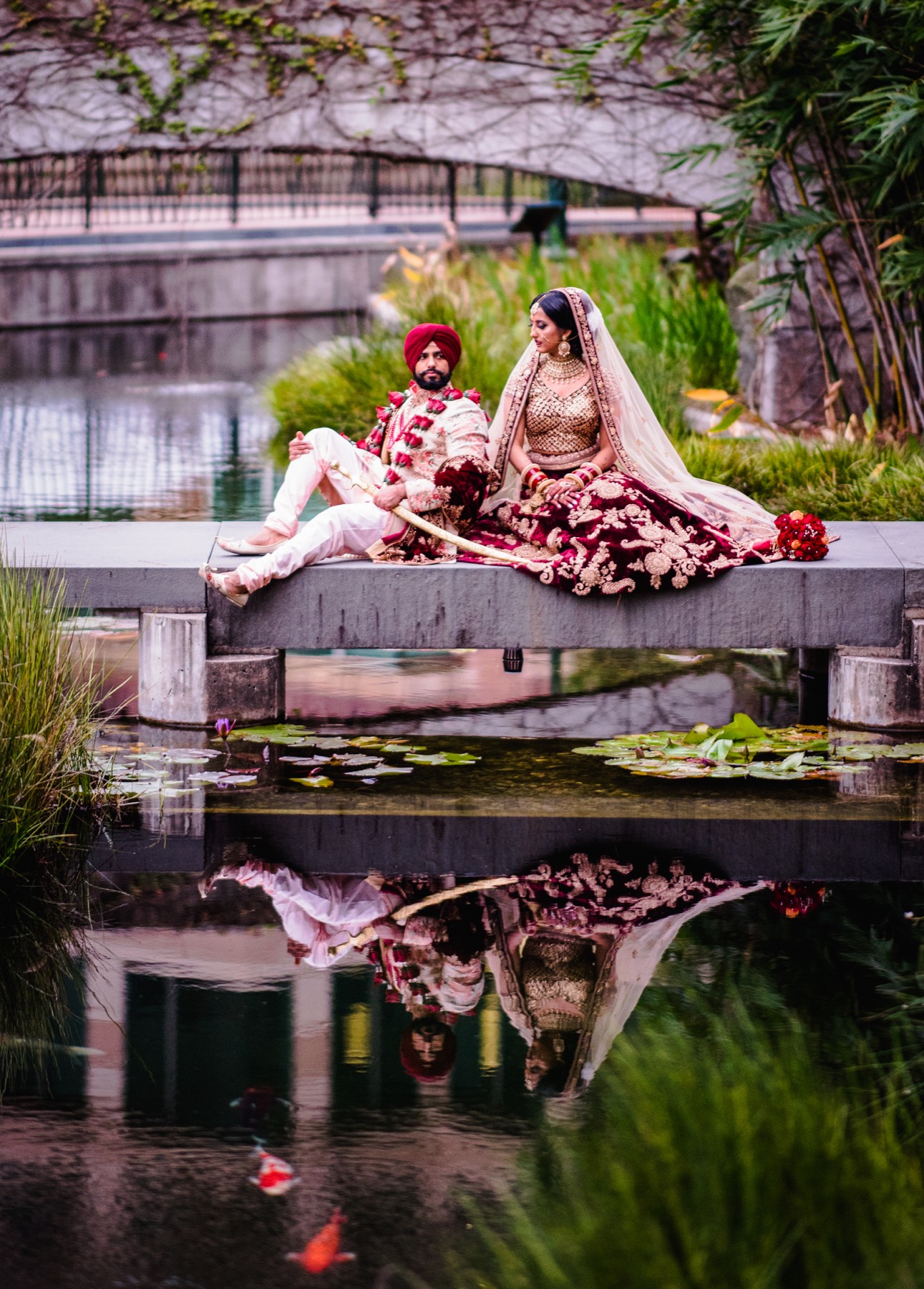 Couple posing together beside a scenic pond